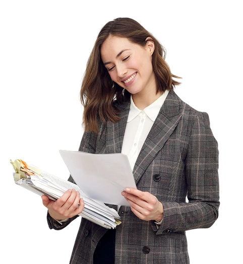 Un homme souriant, vêtu d'une casquette bleue et d'une salopette, tient un bloc-notes et un stylo, debout face à droite sur un fond blanc uni, dégageant une attitude amicale.